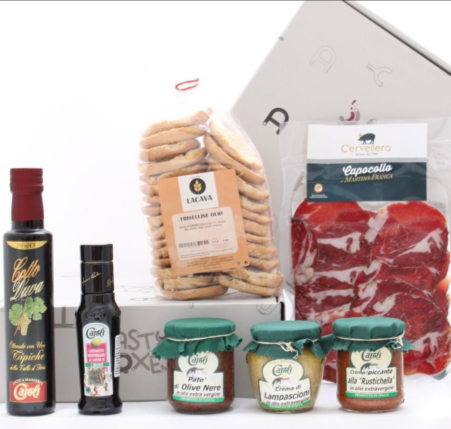 Box assortita di prodotti pugliesi contenente friselline all'olio, olio aromatizzato limone, patè di olive nere, crema di lampascioni, crema piccante alla Rustichella, capocollo a fette sottovuoto, cotto d'uva